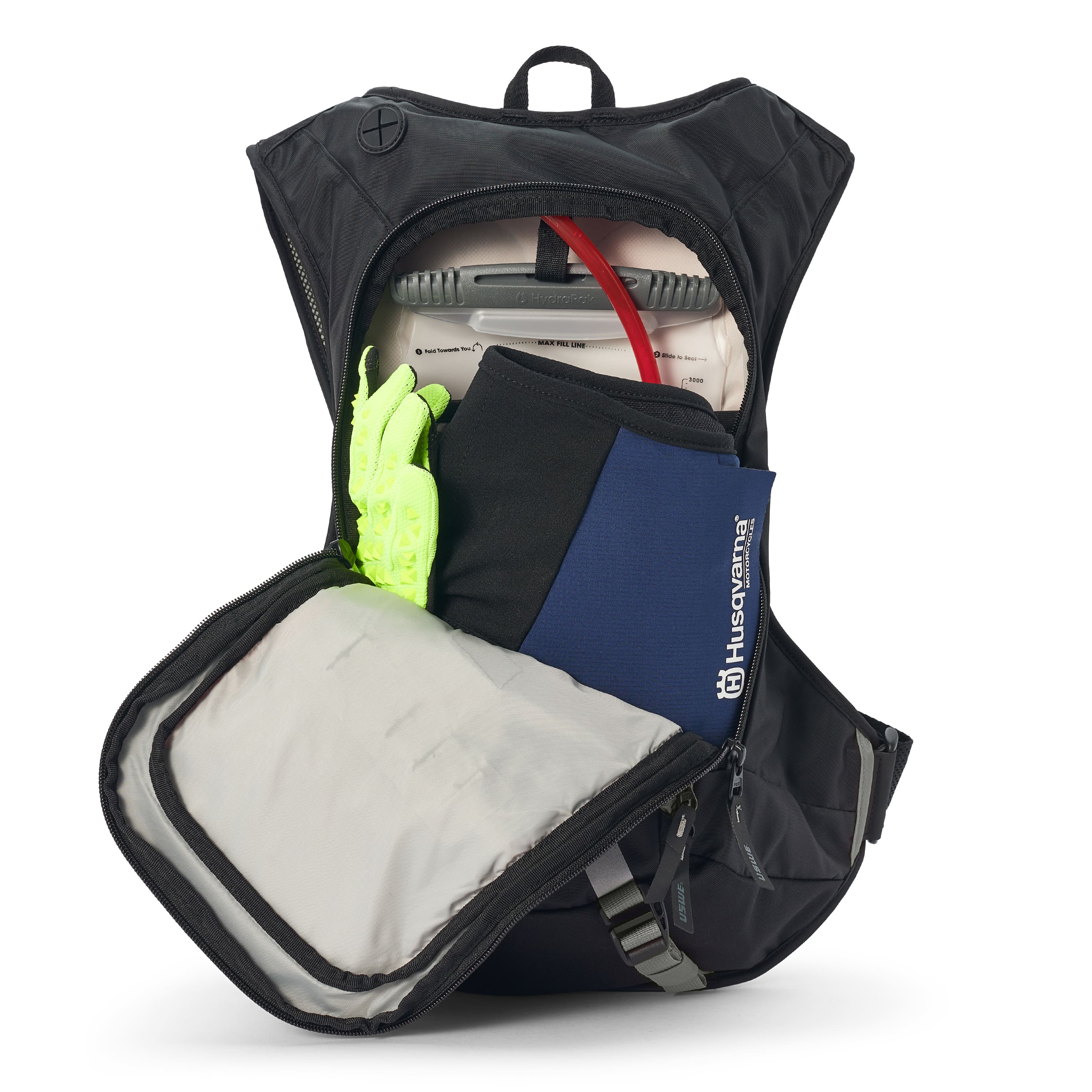 USWE Moto Hydro 12L hydration pack fully opened to show main compartment loaded with spare jacket, tire levers, hydration bladder with red hose, and neon yellow gloves, demonstrating storage layout for motorcycle enduro gear.
