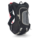 USWE Moto Hydro 12L hydration pack in black and gray with elastic shoulder harness straps, front zippered pocket, and red hydration bladder visible at top.