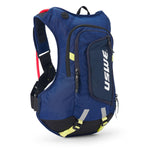 USWE Moto Hydro 12L hydration pack in navy blue with neon yellow bottom straps, red hydration bladder visible at top, and white USWE branding on front zippered pocket, displayed at three-quarter angle showing elastic shoulder harness and compact race fit design.