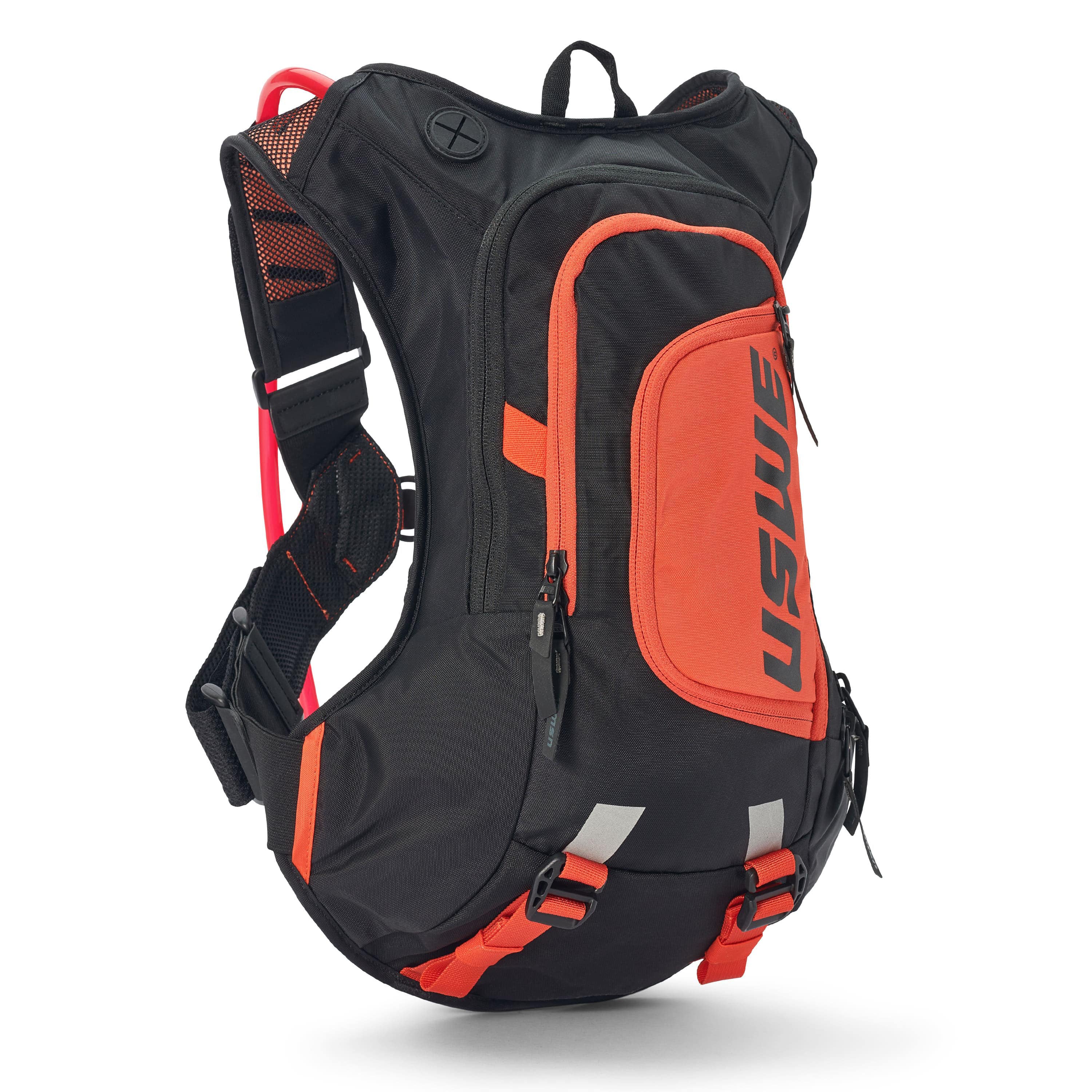 USWE Moto Hydro 12L hydration pack in black and orange colorway, side profile view showing elastic NDM 1.2 shoulder harness with mesh ventilation panels, red hydration hose routing, front zippered pocket with USWE logo, and orange bottom compression straps for securing gear during dirt bike rides.