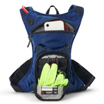 USWE Moto Hydro 3L hydration pack in blue shown fully opened with white smartphone in upper zippered pocket and neon yellow gloves with emergency information card stored in lower detachable organizer compartment, displaying black waist belt with adjustable buckles.