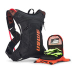 USWE Moto Hydro 3L hydration pack in black and orange with red hydration bladder visible through mesh side panel, displayed with detached front organizer pocket containing emergency card and neon yellow gloves alongside bright orange gear.