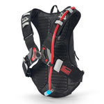 Rear view of USWE Moto Hydro 8L hydration pack showing breathable mesh back panel, red hydration hose with blue bite valve, NDM buckle system with gray and red accents, and No Dancing Monkey label for bounce-free motorcycle riding.