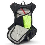 USWE Moto Hydro 8L hydration pack fully opened to display main compartment loaded with 3.0L Elite Hydration Bladder, bright yellow-green riding gloves, and internal storage dividers, demonstrating the pack's 8L carrying capacity for dirt bike gear and accessories.