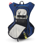 USWE Moto Hydro 8L hydration pack in blue with main compartment wide open, displaying internal tool organizer with three chrome wrenches held by black elastic straps, gray padded interior, and yellow-green reflective accents on waist belt and zipper pulls for dirt bike tool storage.