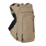 USWE OUTLANDER Moto 9L hydration pack in Sand colorway with vertical black logo branding, dual front zippered pockets with pull cords, and elastic NDM harness with red accents and mesh ventilation panels.