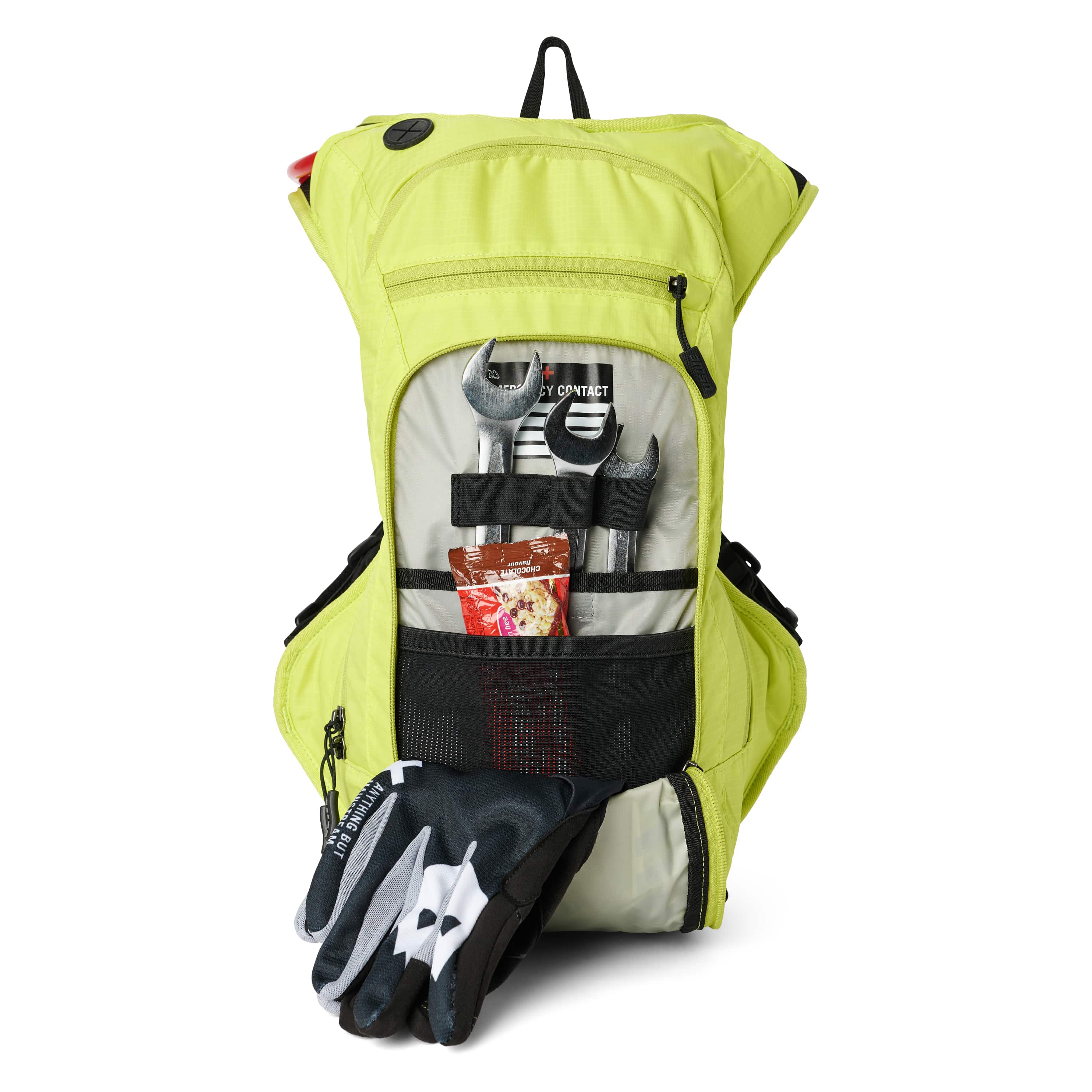 USWE OUTLANDER Moto 9L hydration pack in Crazy Yellow with front compartment unzipped displaying organized tool storage including wrenches, energy gel, and riding gloves secured with elastic straps and mesh pockets.