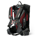 USWE VST Termocell Winter Harness displayed on black daypack showing front view with red mesh ventilation panels, adjustable elastic chest straps, and insulated shoulder strap system designed to prevent hydration tube freezing during winter mountain biking and backcountry adventures.